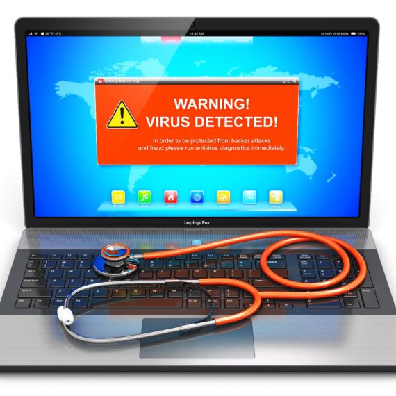 Laptop with virus warning and a stethoscope on keyboard.